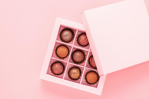 Caramelos de trufa de chocolate en una caja de fondo rosa regalos comida festiva concepto de amor espacio de copia de marco horizontal