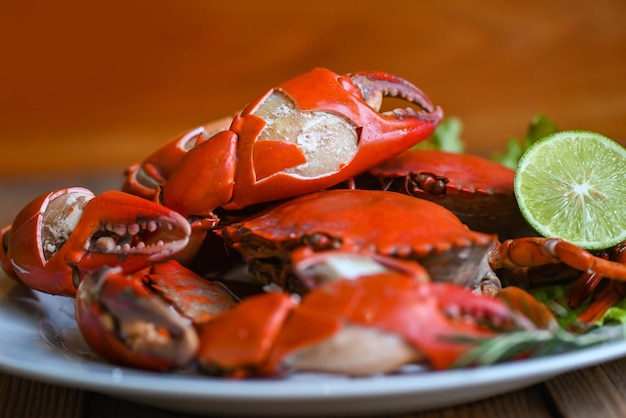 Caranguejo de garra cozinhar comida prato de frutos do mar com ervas especiarias salada de limão limão caranguejo fresco na chapa branca molho de frutos do mar caranguejo cozido ou cozido no vapor vermelho no restaurante