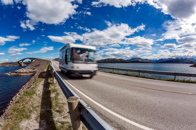 Caravan Car RV fährt auf der Autobahn. Wohnwagen in Bewegungsunschärfe. Norwegen. Atlantic Ocean Road oder der Atlantic Road Atlanterhavsveien wurde der Titel "Norwegischer Bau des Jahrhunderts" verliehen.