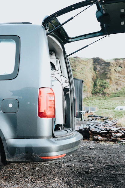 Caravan van está com as portas abertas em frente a uma montanha da Islândia durante uma viagem por estradaVanlife vive em um belo ônibus na natureza abertaViagem épica pelas montanhas Estilo de vida nômade