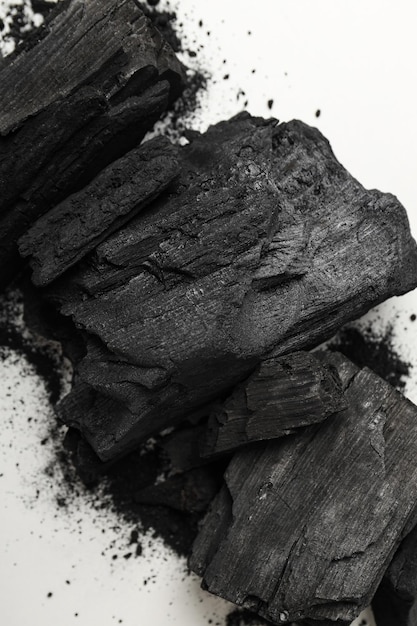 Carbón de leña negro natural sobre fondo blanco.