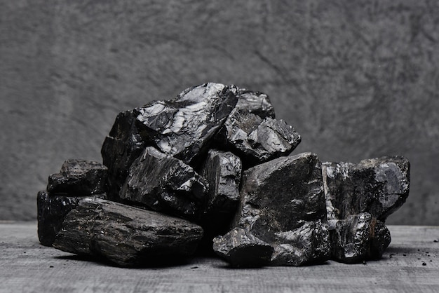 Carbón natural en un primer plano aislado de fondo negro. Extracción de recursos minerales naturales.