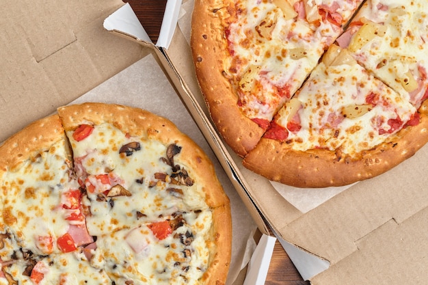 Carbonara e pizza havaiana em uma caixa de papelão com vista superior