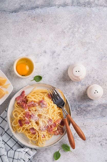 Carbonara-Nudeln Spaghetti mit Pancetta-Ei-Parmesan-Käse und Sahnesoße auf altem grauem Betontischhintergrund Traditionelle italienische Küche und Gericht Pasta alla Carbonara Draufsicht