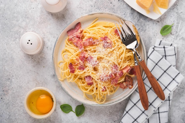 Carbonara-Nudeln Spaghetti mit Pancetta-Ei-Parmesan-Käse und Sahnesoße auf altem grauem Betontischhintergrund Traditionelle italienische Küche und Gericht Pasta alla Carbonara Draufsicht