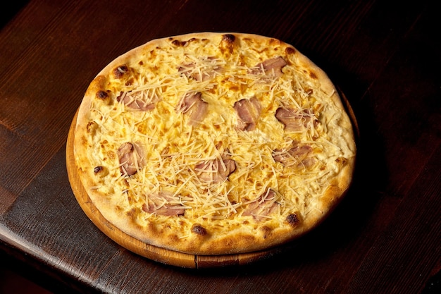 Carbonara de pizza italiana con tocino y queso en una tabla de madera. Cocina italiana. De cerca