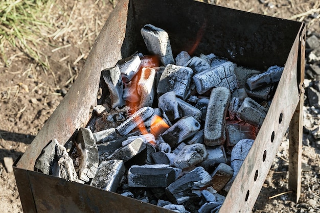Carbones quemados para barbacoa en la antigua parrilla al aire libre Carbones encendidos en el brasero de hierro