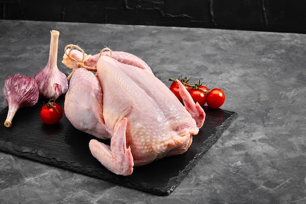 Carcaça de frango fresco em uma superfície cinza, carne fresca, espaço de cópia, foto para supermercados