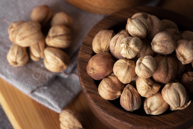 Cardamomo blanco en una cuchara de madera y un tazón Especia de cardamomo seco Semillas de cardamomo tiro macro