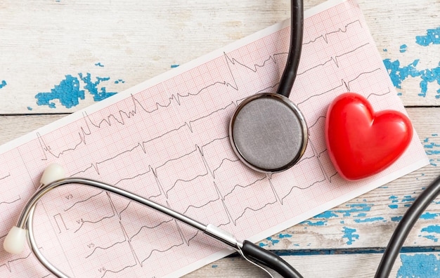 Cardiograma com estetoscópio e coração vermelho em cima da mesa