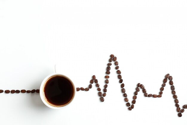 Cardiograma pintado con granos de café de fondo con espacio para texto en la parte superior.