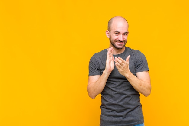 Careca feliz e bem-sucedida, sorrindo e batendo palmas, parabenizando-se com aplausos