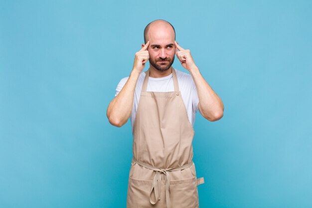 Careca sentindo-se confuso ou duvidando, concentrando-se em uma ideia, pensando muito, procurando copiar o espaço ao lado