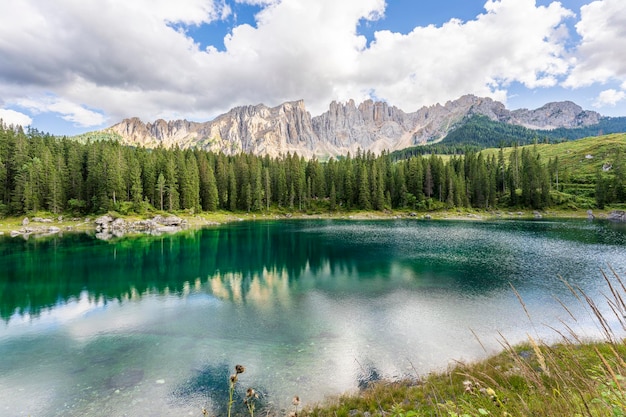 Carezza Lake an einem sonnigen Tag mit etwas Wolken