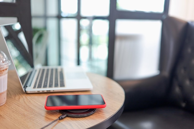 Carga de la batería del teléfono móvil con un dispositivo inalámbrico en la mesa Carga del teléfono inteligente en una plataforma de carga Teléfono móvil cerca del cargador inalámbrico