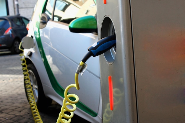 Carga de un coche eléctrico con el cable de alimentación enchufado.