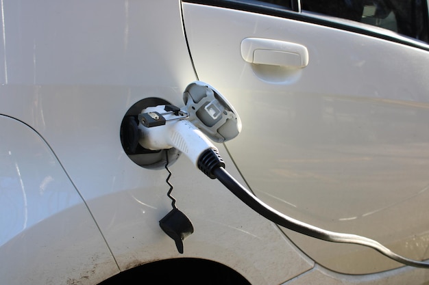 Carga de un coche eléctrico completo en una estación de carga pública en la calle de la ciudad