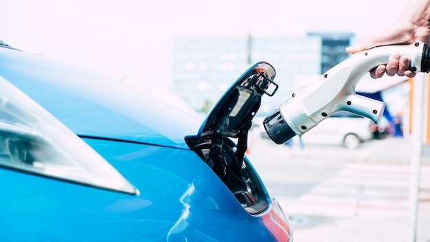 Carga del coche eléctrico en una estación especial al aire libre. Adaptador para asas de mano macho