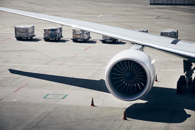 Foto carga de contenedores de carga en el avión en el aeropuerto de manejo en tierra preparando el avión antes del vuelo