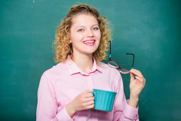 Carga de energia de energia e vigor bom dia garota refrescante com bebida de chá professora precisa de ideia de pausa para café e mulher de inspiração com xícara de café no quadro-negro de manhã cedo