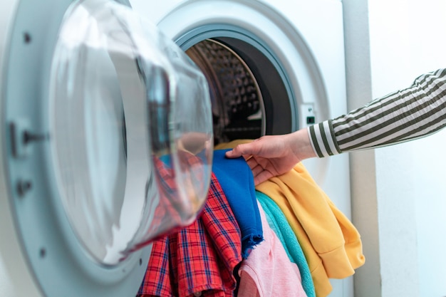 Carga de ropa y ropa de colores en la lavadora. Lavar la ropa en casa