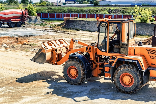 Un cargador frontal grande transporta piedra triturada o grava en un balde en un sitio de construcción o planta de concreto Transporte de materiales a granel Equipos de construcción Transporte de carga a granel