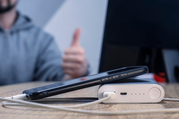 cargador portátil carga un teléfono inteligente en una mesa de madera