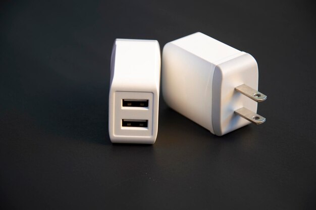 Cargador USB tipo 2 puertos blanco colocado sobre un fondo negro