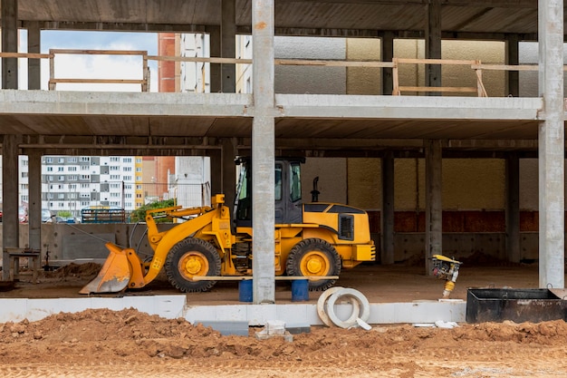 Foto cargadora de ruedas pesadas con una cuchara en un sitio de construcción equipo de cierre para transporte de movimiento de tierras y carga de materiales a granel tierra arena piedra triturada