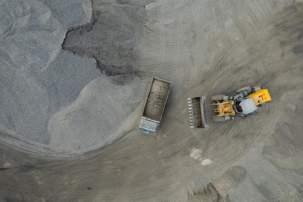 Cargadores de arena están paleando rocas en camiones volquete