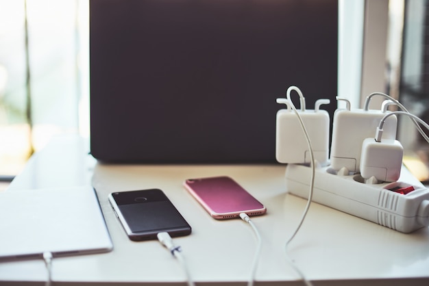 Cargadores de teléfono y computadora portátil en la mesa