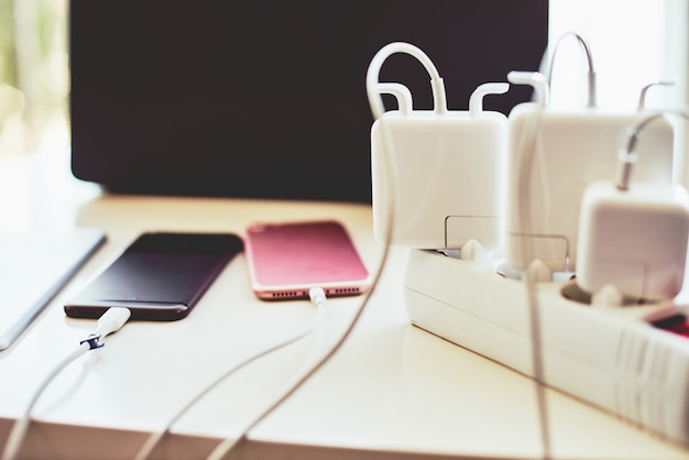 Cargadores de teléfono y computadora portátil en la mesa