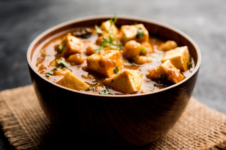 Foto caril chole paneer feito com grão de bico cozido com queijo cottage e especiarias. receita popular do norte da índia. servido em uma tigela ou travessa. foco seletivo
