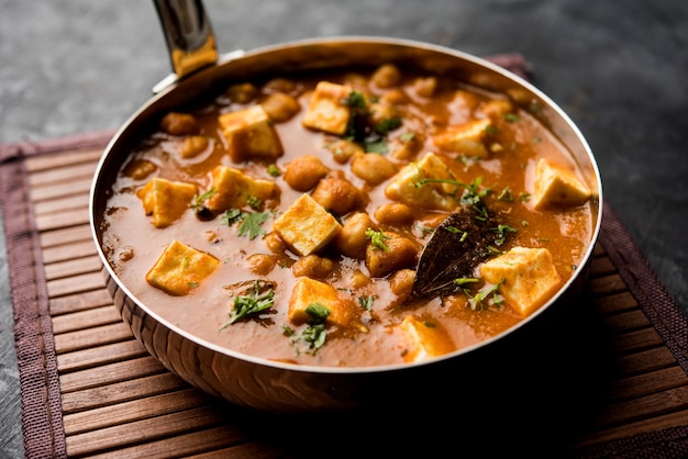 Caril Chole Paneer feito com grão de bico cozido com queijo cottage e especiarias. Receita popular do norte da Índia. servido em uma tigela ou travessa. Foco seletivo