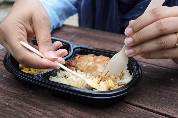 Caril de frango e arroz em um pacote de plástico para viagem na mesa