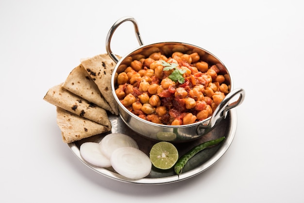 Caril de grão de bico picante, Chana Masala ou Choley em tigela com chapati e salada. Prato tradicional do norte da Índia.