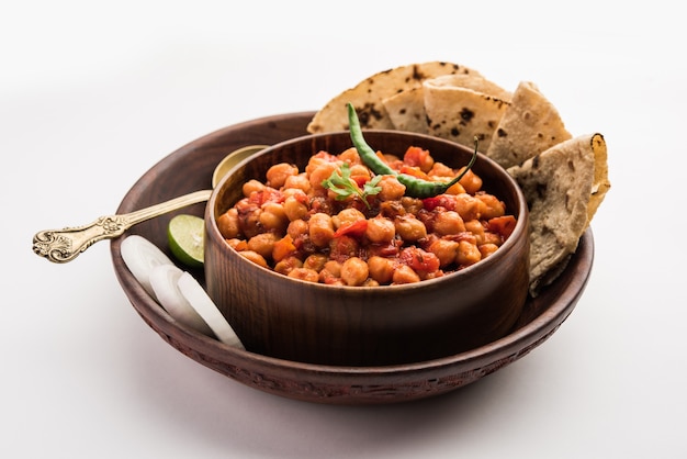 Caril de grão de bico picante, Chana Masala ou Choley em tigela com chapati e salada. Prato tradicional do norte da Índia.