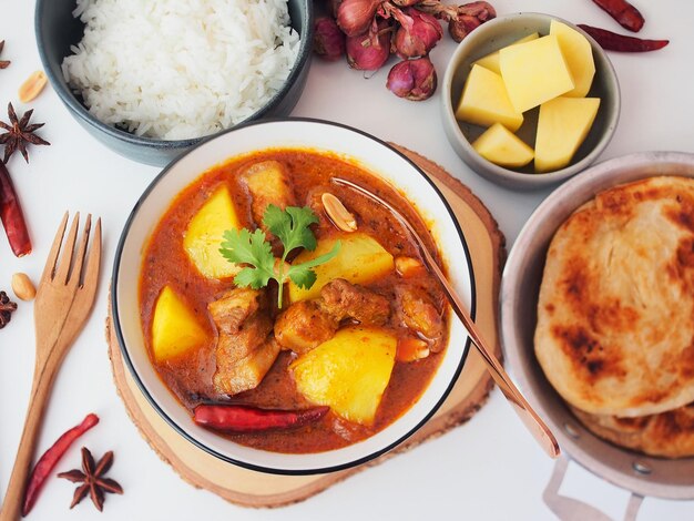 Caril de massaman de porco barriga servir com roti e arroz