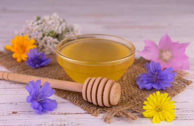 Cariño. La miel de flores frescas fluye por un palo de madera.