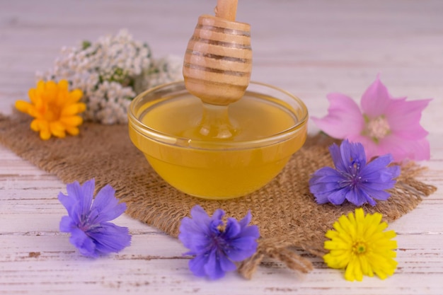 Cariño. La miel de flores frescas fluye por un palo de madera.