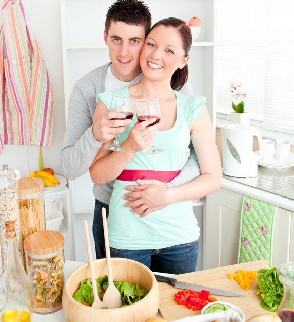 Cariñosa pareja bebiendo vino en la cocina