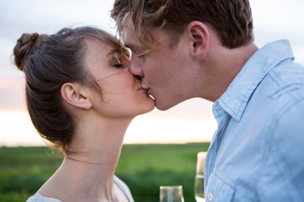 Cariñosa pareja besándose en el campo