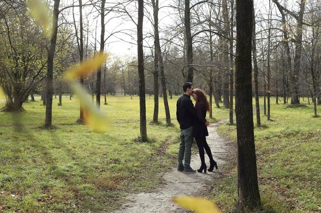 Cariñosa pareja en el bosque en otoño