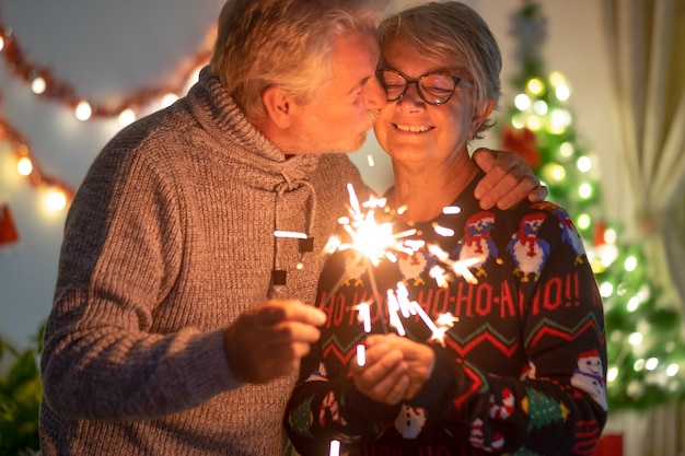 Un cariñoso beso entre anciana y esposo que celebran la Navidad con chispas