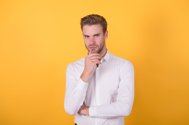 Carisma masculino barbearia e cabeleireiro beleza e moda na moda cara bonito com cabelo eriçado no rosto bonito jovem confiante de pé em uma camisa branca empresário bem preparado