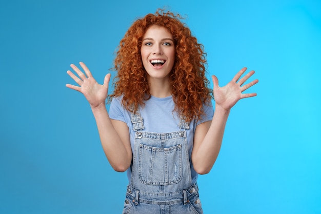 Carismática brilhante feliz divertida ruiva bonita verão gengibre levantar as mãos encantado aplaudindo lisonjeado sorrindo amplamente branco sorriso aberto expressar felicidade alegria fundo do estúdio.