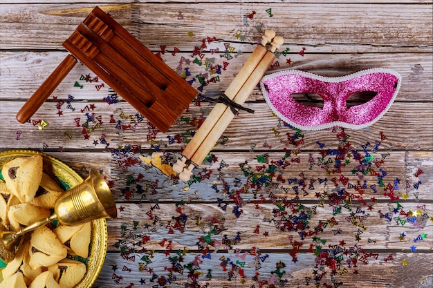 Carnaval judío celebración de Purim en galletas hamantaschen, matraca y máscara con pergamino