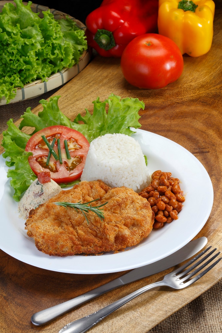 Foto carne à milanesa com arroz, feijão, salada e farofa.