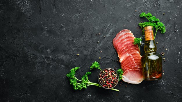 Carne ahumada con especias y hierbas Sobre un fondo de madera negra Vista superior Espacio libre para el texto