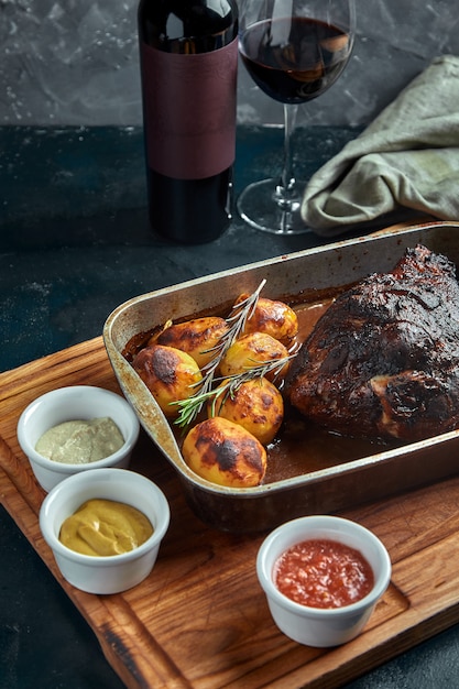 Carne al horno y papas. Una comida deliciosa y abundante. Un gran trozo de carne al horno. Comida caliente cocida.